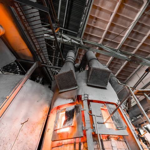 A fired furnace with burner assemblies and flue ducting overhead